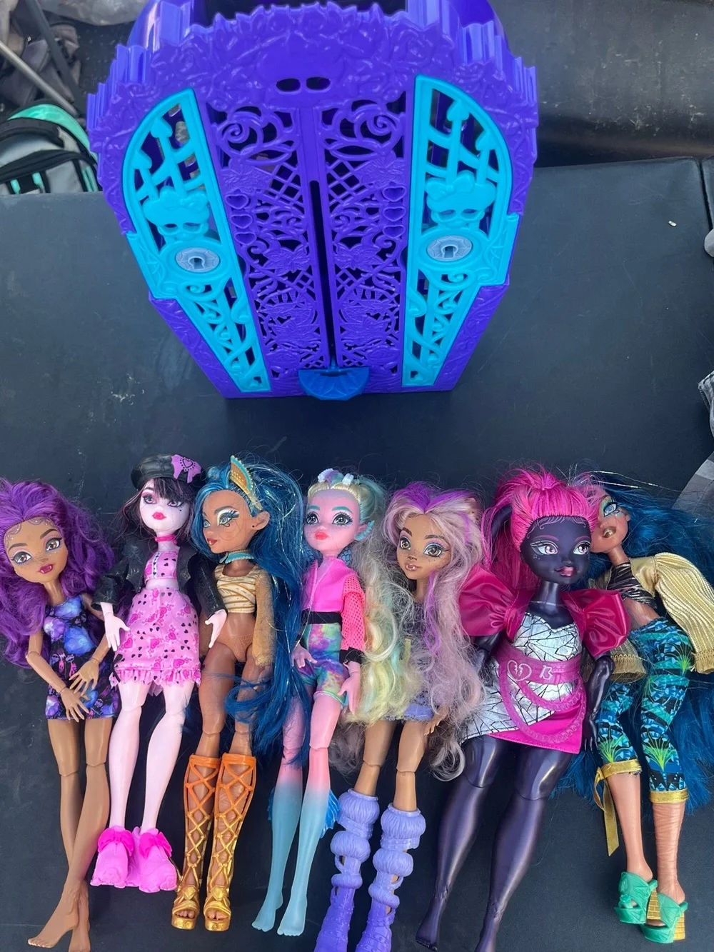 monster high dolls set with purple, teal, pink and blue carrier